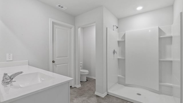 bathroom with a shower, vanity, and toilet