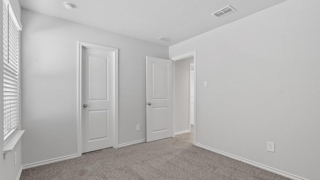 unfurnished bedroom with light colored carpet