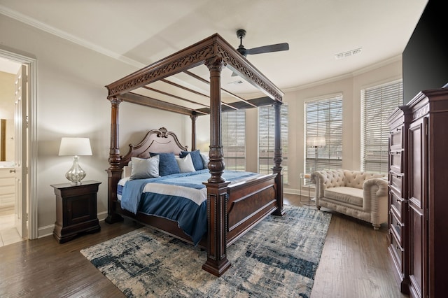 bedroom with crown molding, connected bathroom, ceiling fan, and dark hardwood / wood-style flooring