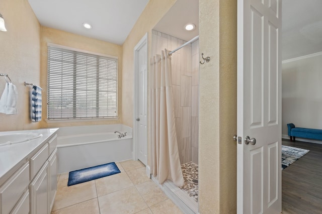 bathroom with tile patterned flooring, vanity, and independent shower and bath