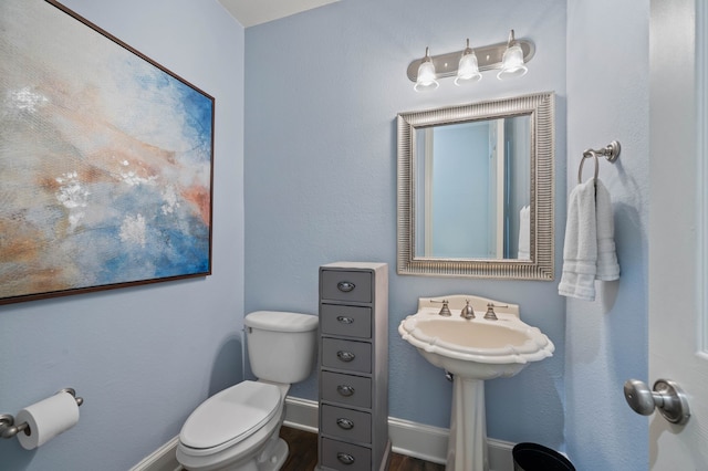 bathroom with hardwood / wood-style flooring, sink, and toilet