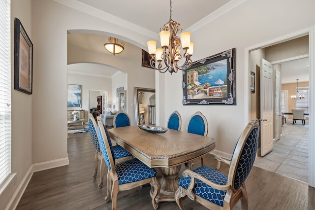 dining area featuring crown molding, dark hardwood / wood-style floors, and a chandelier