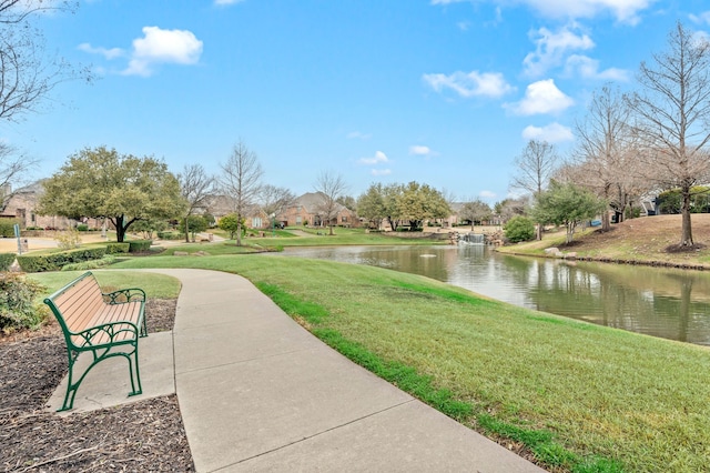 view of home's community featuring a water view and a lawn