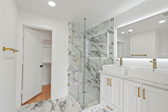 bathroom featuring recessed lighting, marble finish floor, a sink, and a marble finish shower