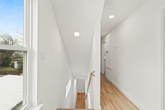 corridor with light wood-type flooring, baseboards, and recessed lighting