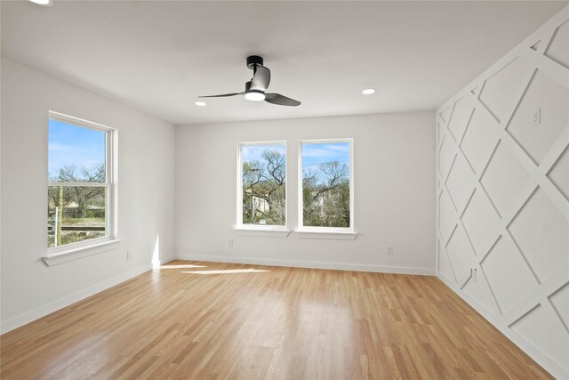 unfurnished bedroom with light wood-style floors, multiple windows, and baseboards