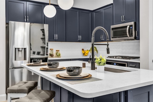 4413 Murphy Ln, Carrollton, TX 75010 - kitchen featuring decorative light fixtures, a kitchen bar, blue cabinetry, stainless steel appliances, and a kitchen island with sink