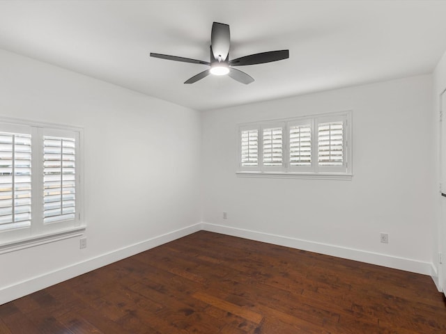 spare room featuring dark hardwood / wood-style flooring, ceiling fan, and a healthy amount of sunlight