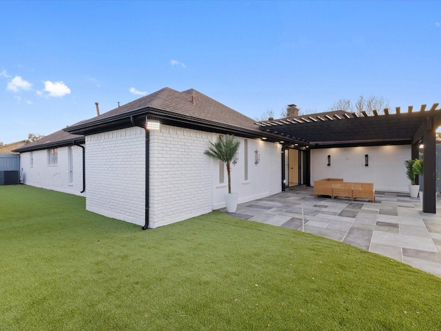 rear view of property with a yard, a pergola, a patio area, and central AC