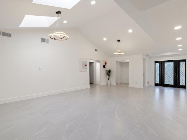 unfurnished living room with a skylight and high vaulted ceiling