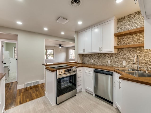 kitchen with visible vents, appliances with stainless steel finishes, white cabinetry, open shelves, and a sink