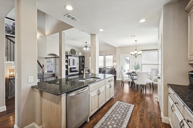 kitchen with decorative light fixtures, sink, dark stone counters, stainless steel dishwasher, and dark wood-type flooring