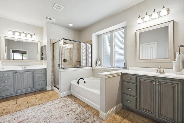 bathroom with tile patterned floors, plenty of natural light, separate shower and tub, and vanity