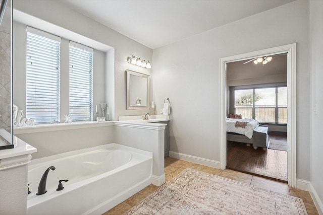 bathroom featuring tile patterned flooring, a tub to relax in, and vanity