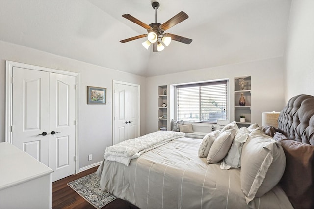 bedroom with multiple closets, vaulted ceiling, ceiling fan, and dark hardwood / wood-style flooring