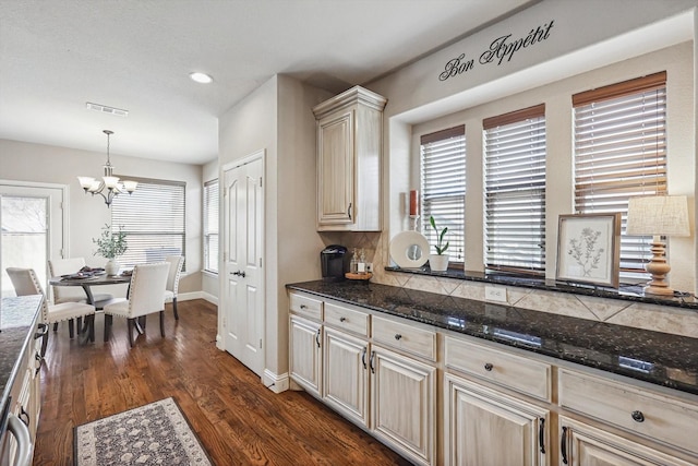 kitchen with pendant lighting, dark hardwood / wood-style flooring, and dark stone counters