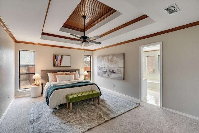 bedroom featuring ensuite bathroom, ornamental molding, ceiling fan, a raised ceiling, and light carpet