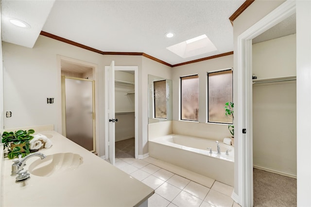 bathroom with a skylight, a textured ceiling, ornamental molding, independent shower and bath, and tile patterned flooring