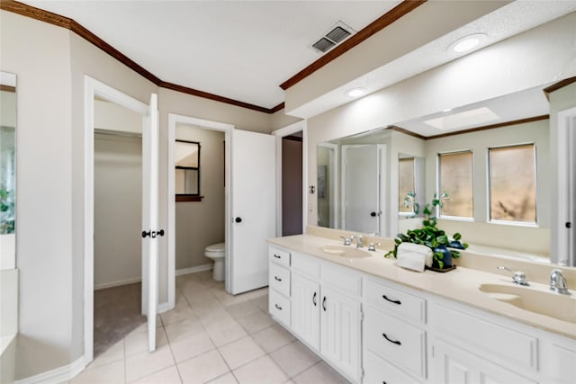 bathroom featuring vanity, tile patterned flooring, crown molding, and toilet