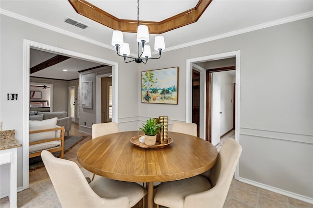 dining space with ornamental molding, an inviting chandelier, and a tray ceiling