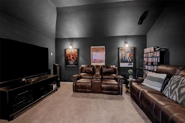 cinema room featuring light carpet and vaulted ceiling