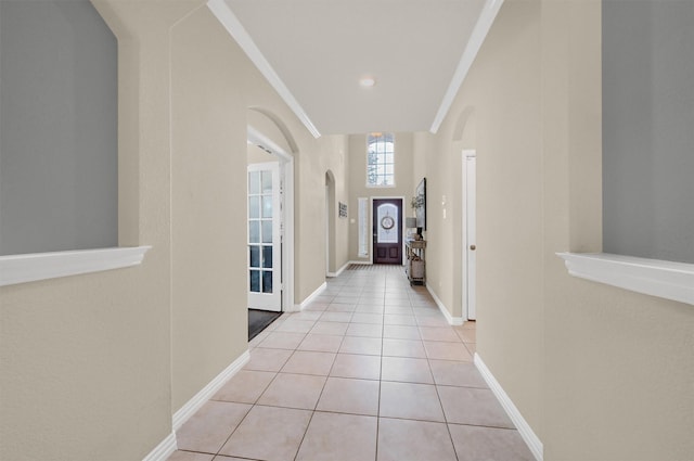 hall featuring ornamental molding and light tile patterned floors