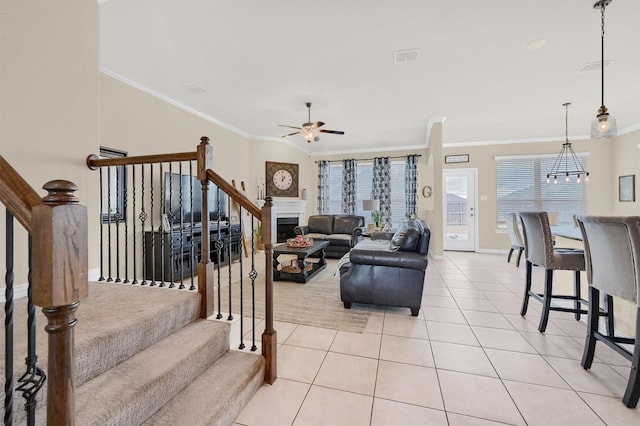 living room featuring light tile patterned floors, ornamental molding, and ceiling fan