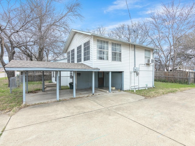 view of front of house featuring cooling unit, a front yard, and a carport