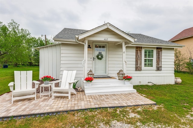 view of front of home with a front yard and a patio area