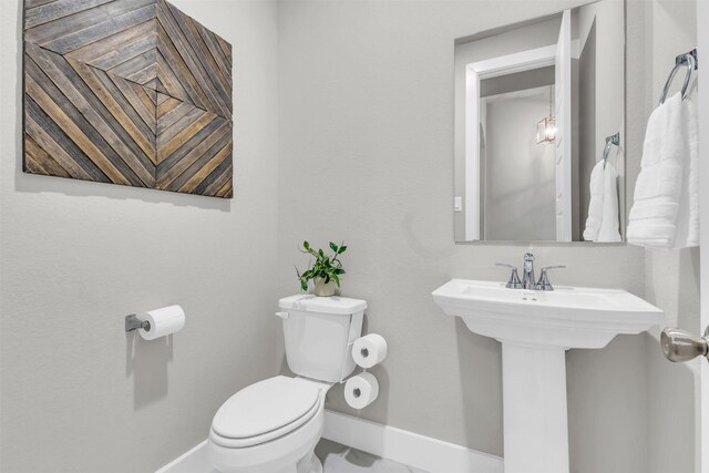 kitchen with white cabinets, a sink, decorative light fixtures, and an island with sink