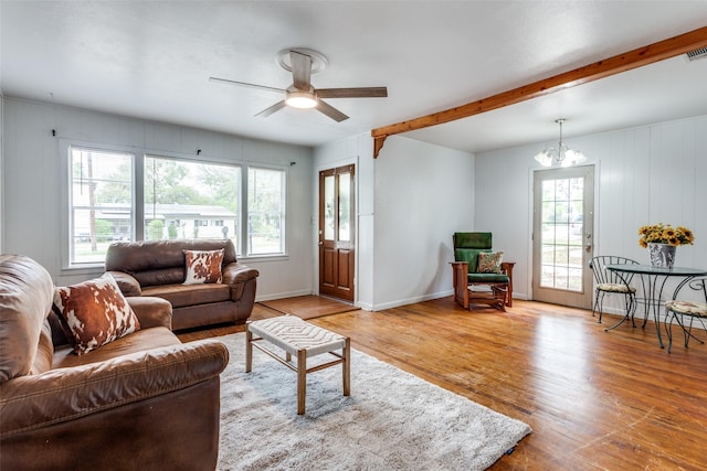 living room with plenty of natural light, beam ceiling, ceiling fan with notable chandelier, and light hardwood / wood-style flooring