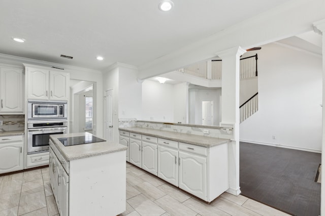 kitchen featuring white cabinetry, a kitchen island, and appliances with stainless steel finishes