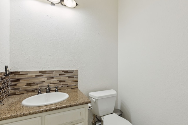 bathroom with tasteful backsplash, vanity, and toilet