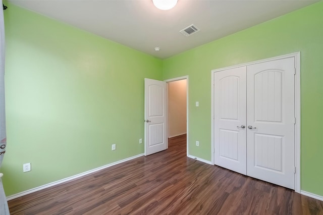 unfurnished bedroom featuring dark hardwood / wood-style floors and a closet