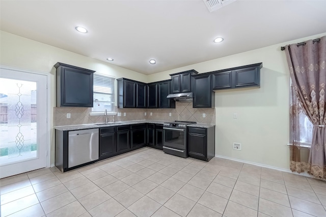 kitchen featuring stainless steel appliances, light stone countertops, sink, and backsplash