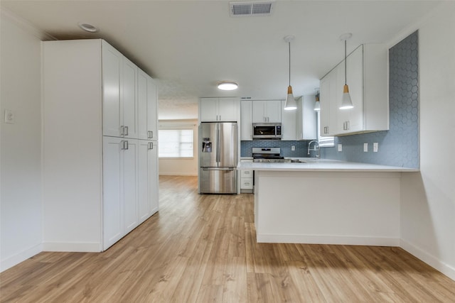 kitchen with white cabinetry, light hardwood / wood-style flooring, appliances with stainless steel finishes, kitchen peninsula, and backsplash