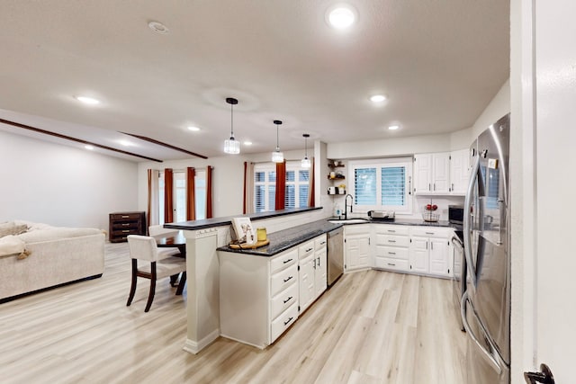 6808 Westglen Dr, Fort Worth, TX 76133 - kitchen with pendant lighting, stainless steel appliances, light hardwood / wood-style floors, white cabinets, and kitchen peninsula