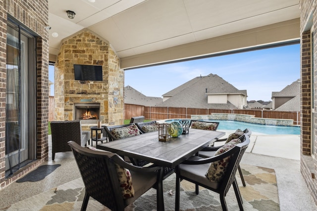 view of patio featuring outdoor dining area, a fenced backyard, a fenced in pool, and an outdoor stone fireplace