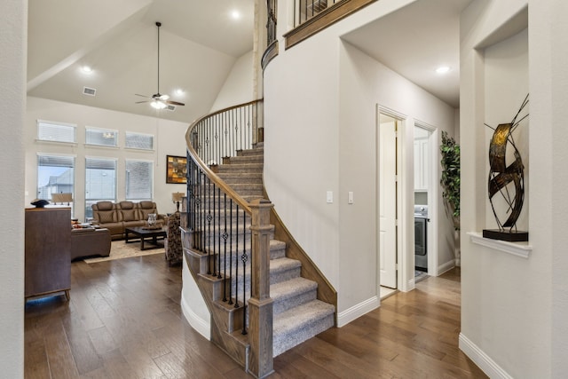 stairs with high vaulted ceiling, ceiling fan, and hardwood / wood-style flooring