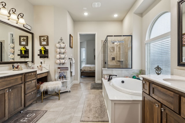 full bathroom featuring tile patterned floors, a garden tub, two vanities, a stall shower, and ensuite bath