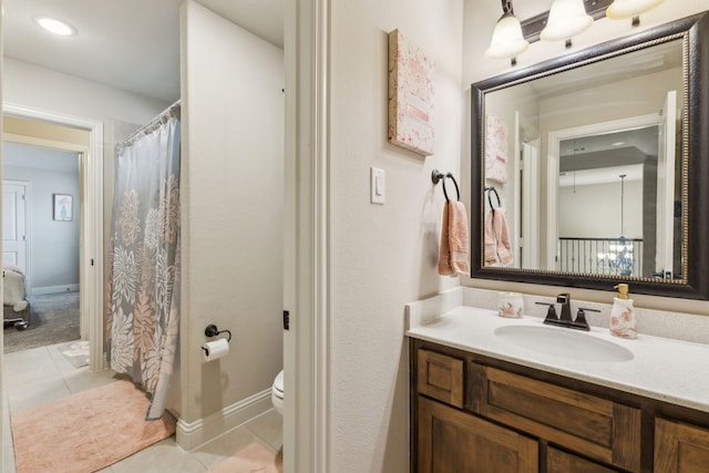 bathroom featuring tile patterned floors, toilet, vanity, and baseboards