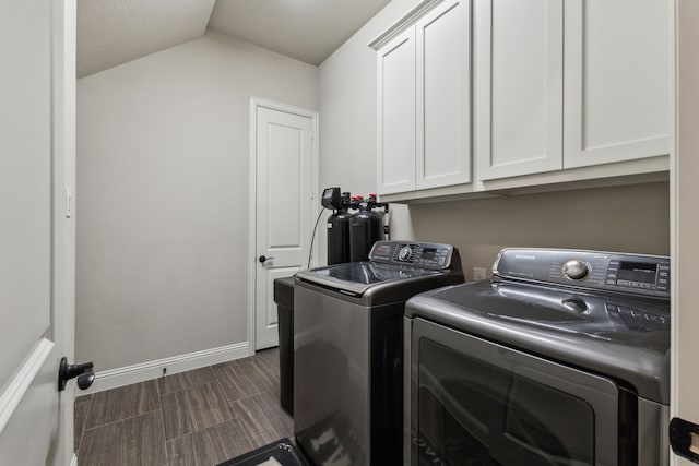 laundry area featuring washing machine and dryer, cabinet space, and baseboards