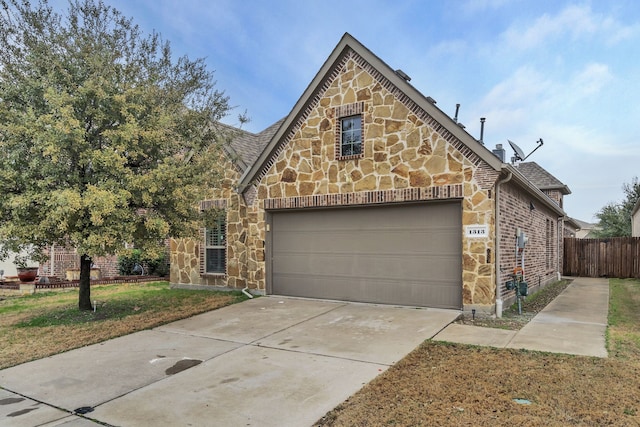 english style home featuring a garage and a front yard