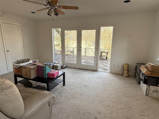 carpeted living area with french doors and a ceiling fan