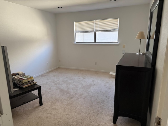 bedroom with light colored carpet and baseboards