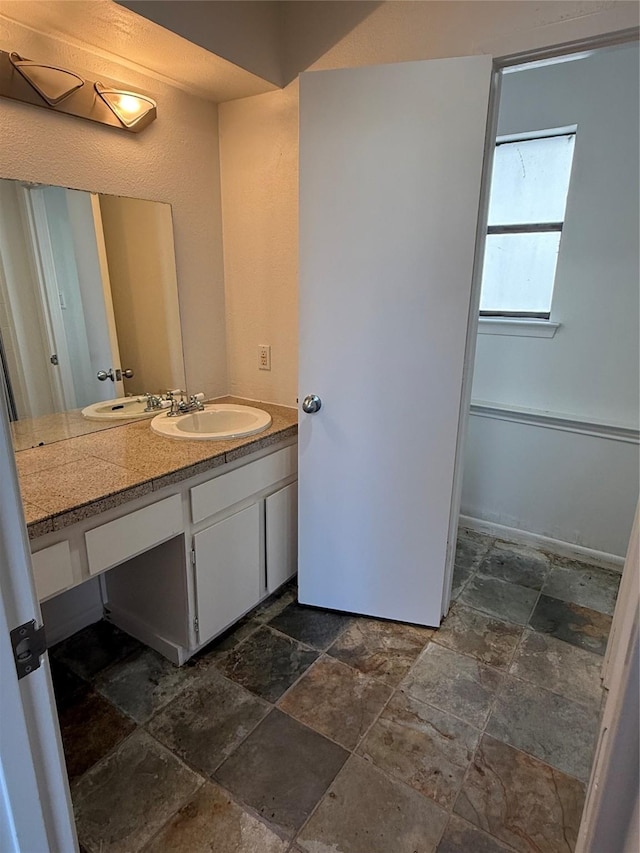 bathroom with stone finish floor and vanity