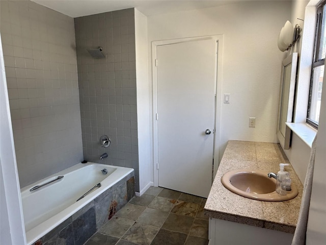 bathroom with tiled shower / bath and vanity