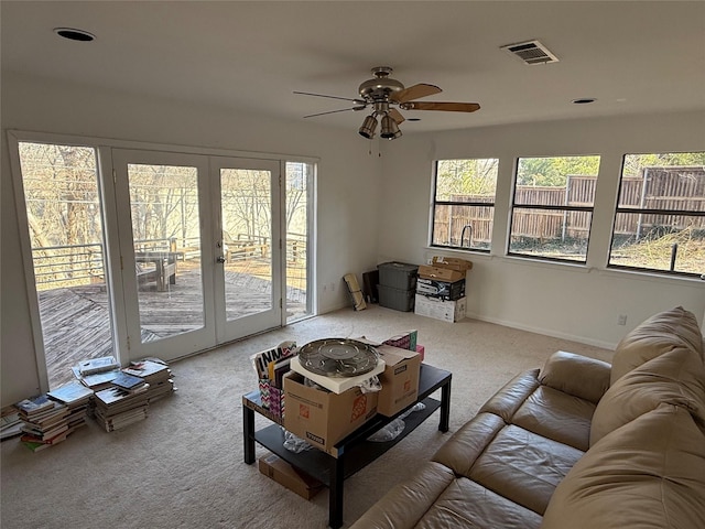 living room with carpet floors, french doors, visible vents, and a ceiling fan