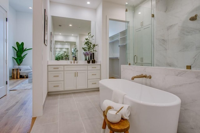 bathroom featuring independent shower and bath, vanity, and tile patterned floors