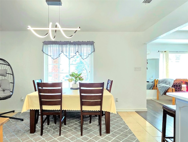 tiled dining area featuring a notable chandelier